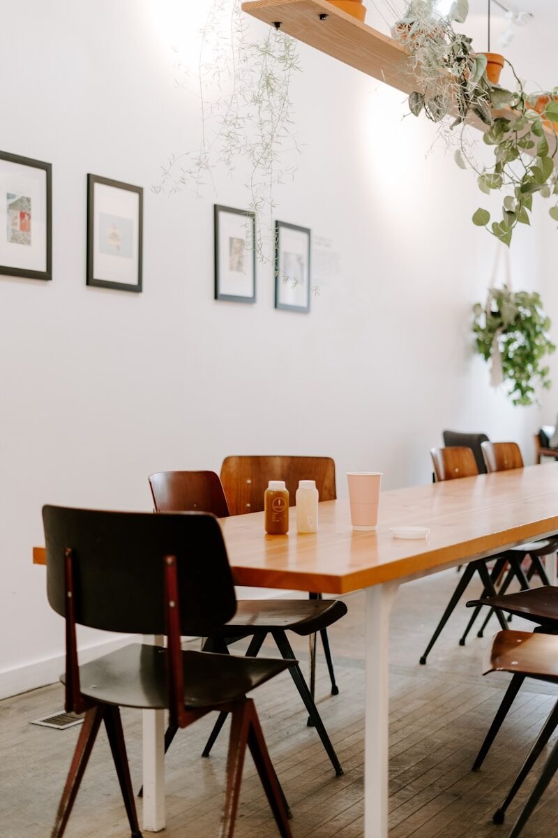 Table de réunion en bois dans une salle claire décorée de plantes