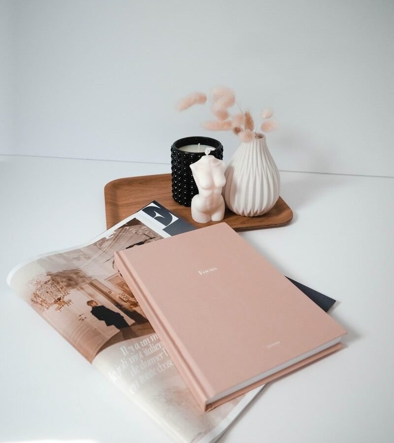 Livre rose posé sur une table blanche